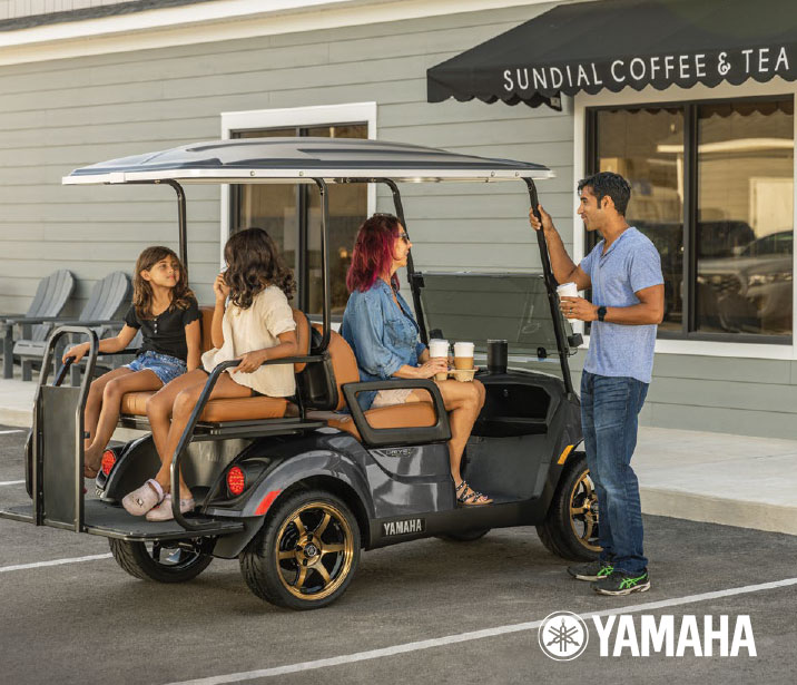 Family sitting in front of a ice cream shop i in a Yamaha Drive 2 gas powered